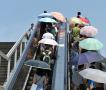 北京入伏最高温达40度 市民举遮阳伞挡烈日暴晒